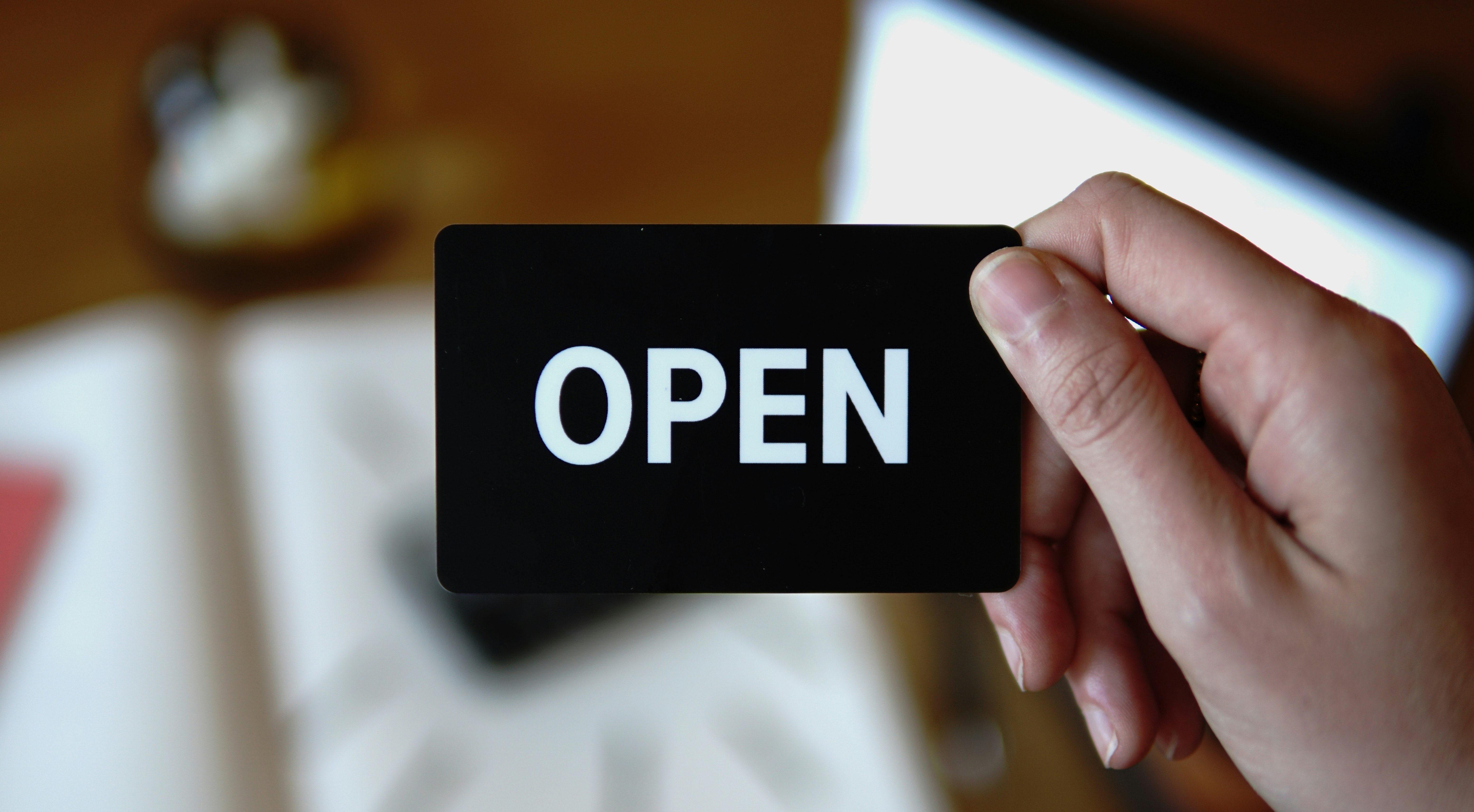 person holding white and black Open card